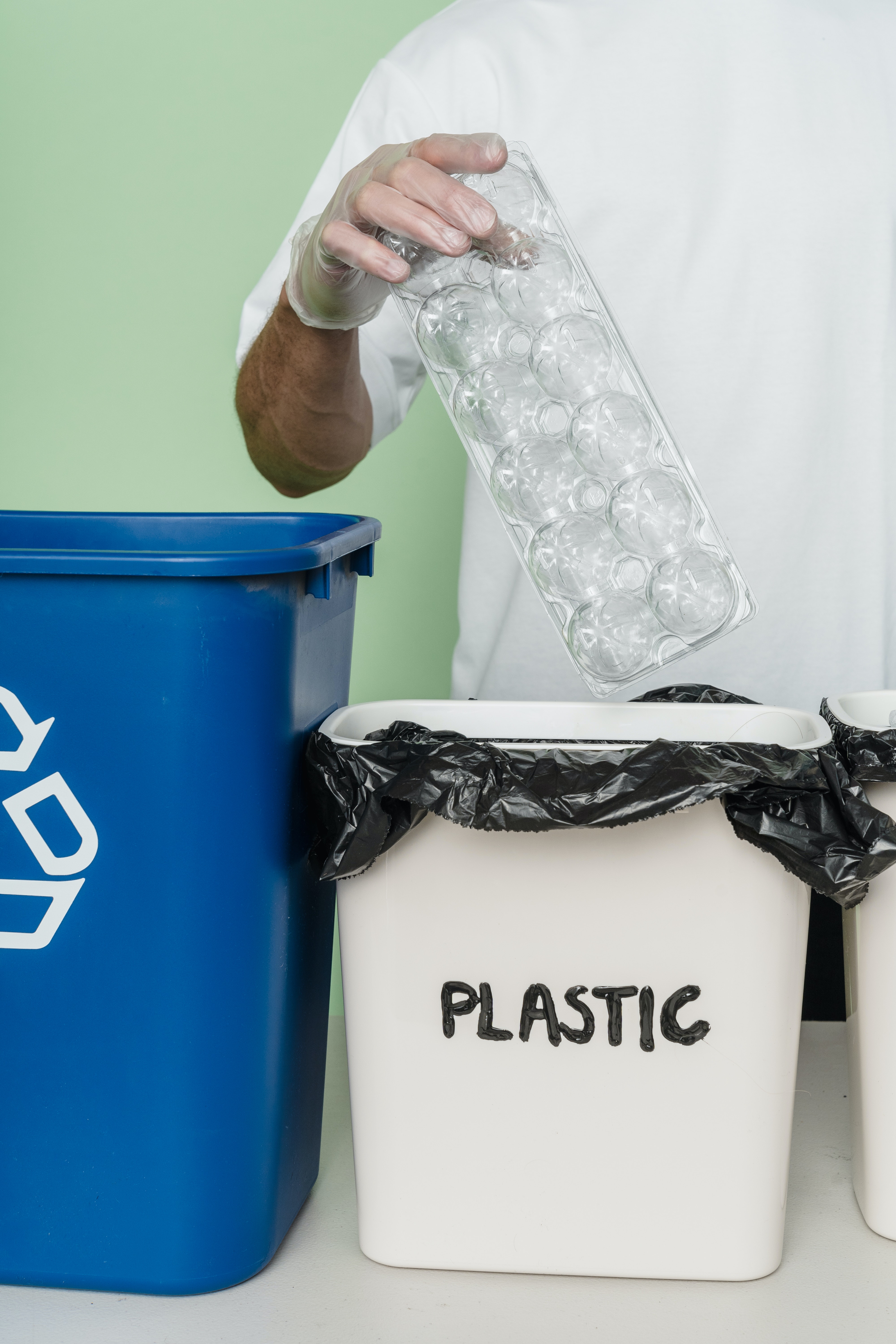 pessoa colocando plástico no lixo para plásticos